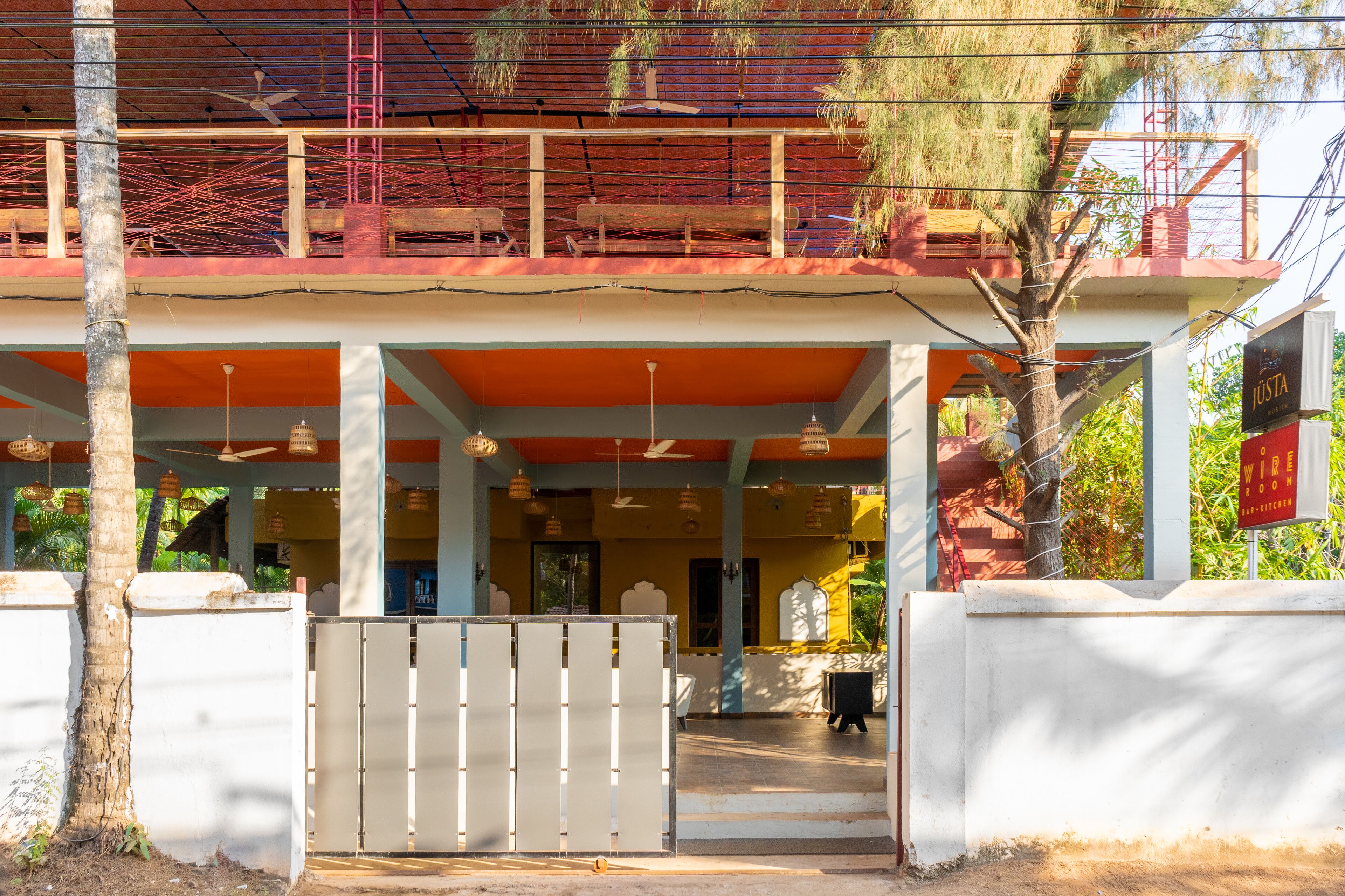 A two-story building with a covered entrance, a gated area, and a sign for 'Justa'.