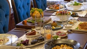 Una mesa de comedor preparada con diferentes platos, vasos y cubiertos.