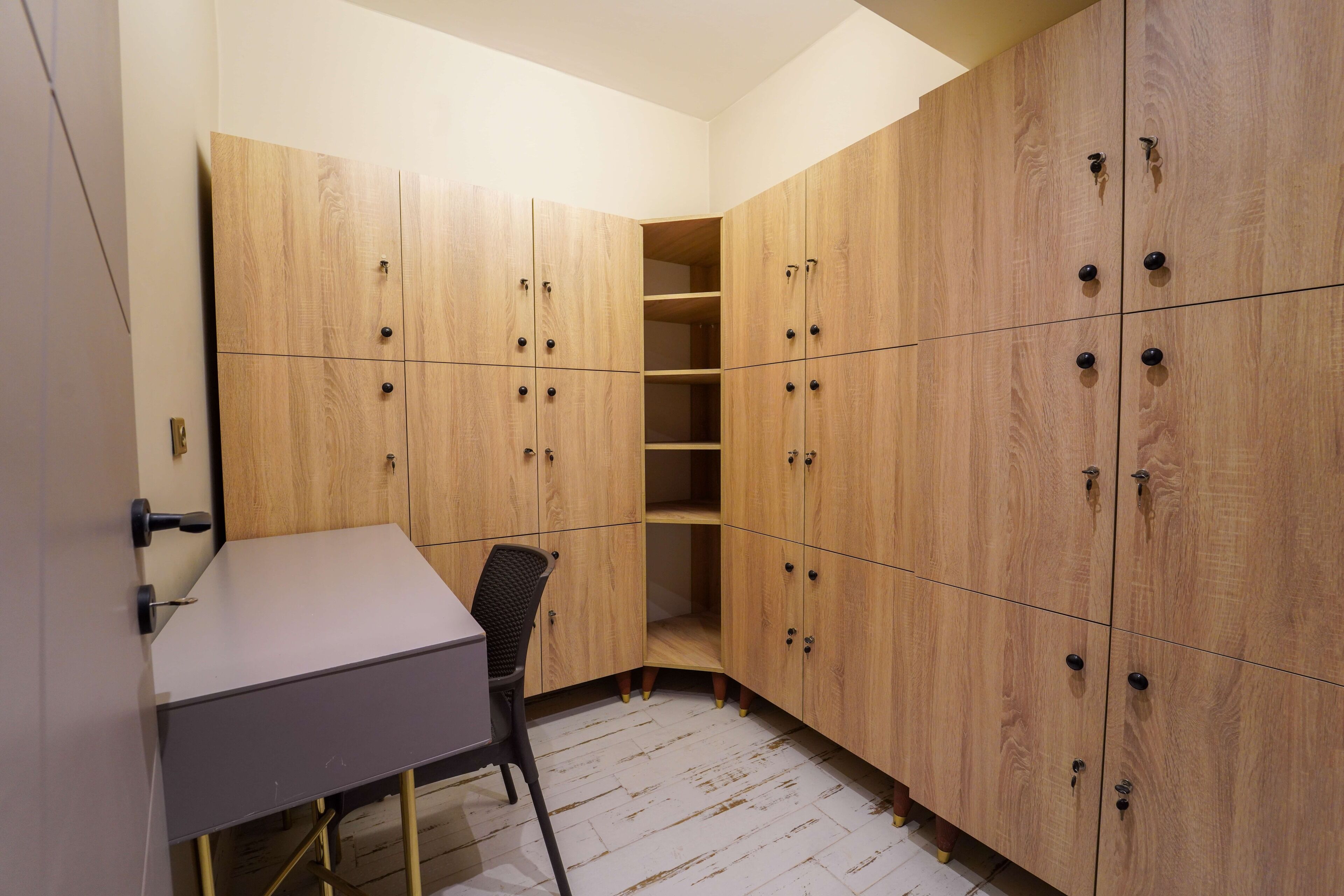 Una habitación de esquina con armarios de madera, un escritorio y una silla.