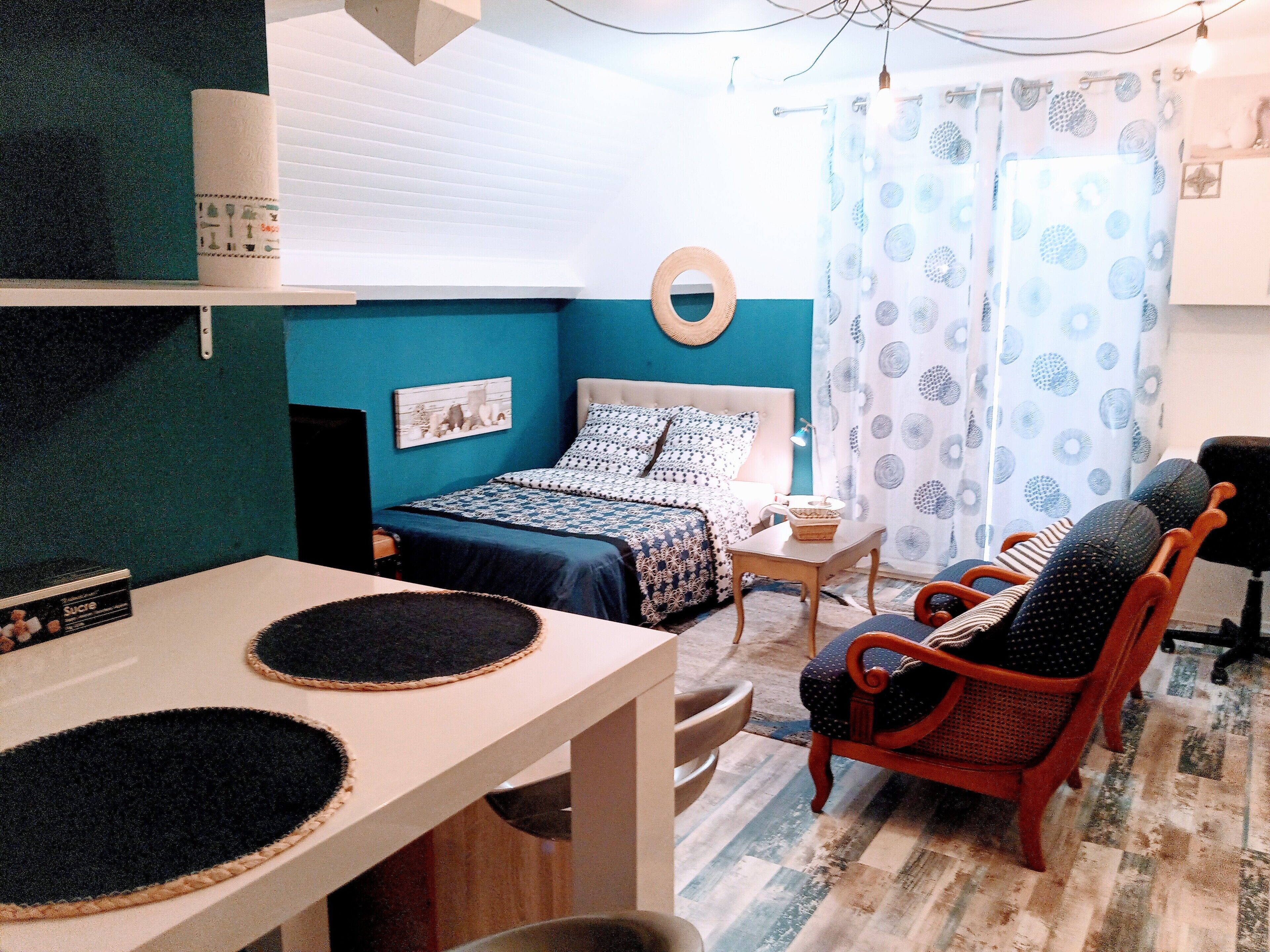 A compact room with a bed, a table, and two chairs.