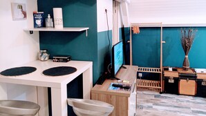 A compact living space with a kitchenette, a small dining area, and a seating area. - Casa Azur - Charming Palois studio with free parking 24/24 (Pau)