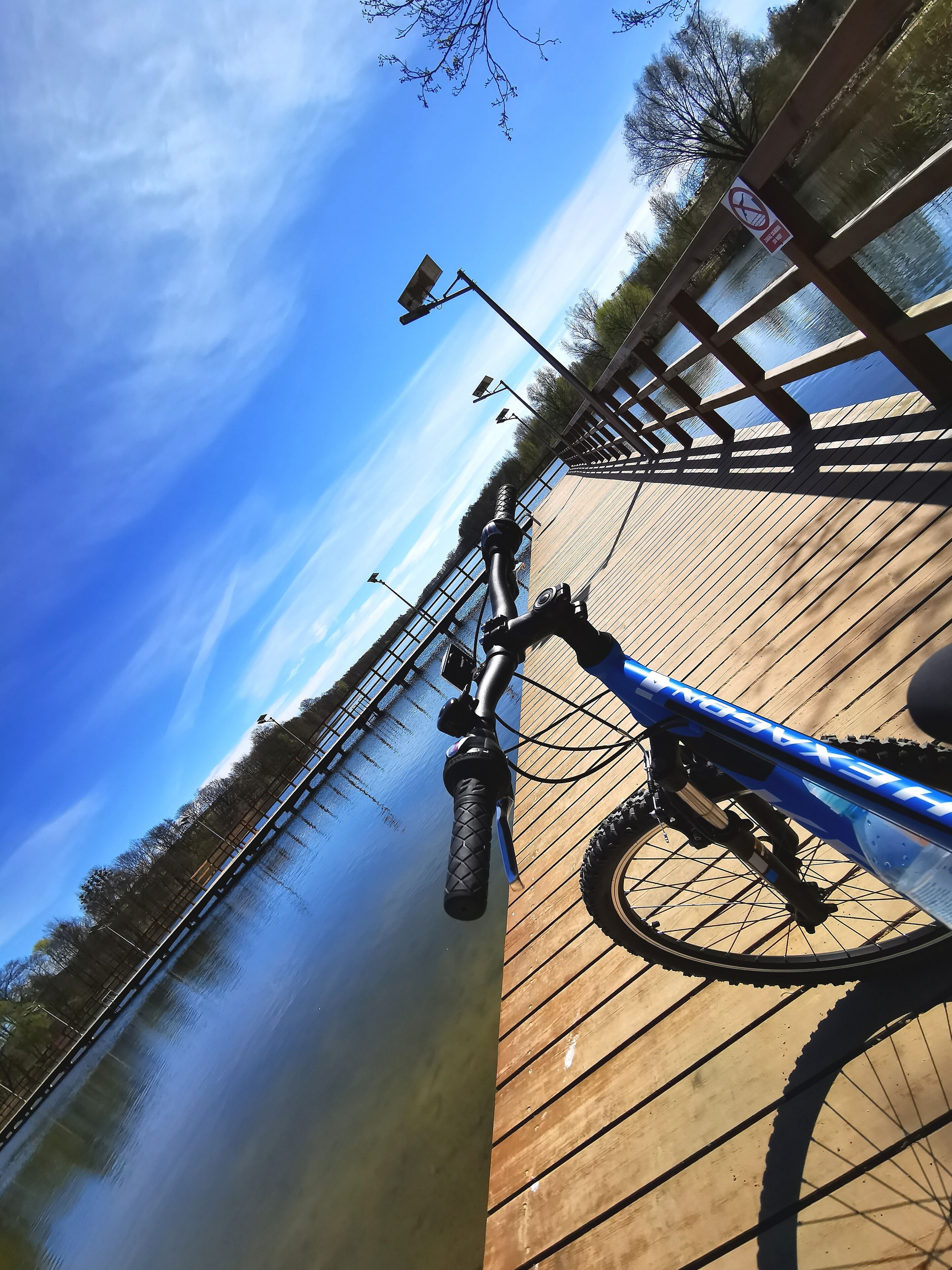 A bicycle on a wooden bridge with a clear sky.