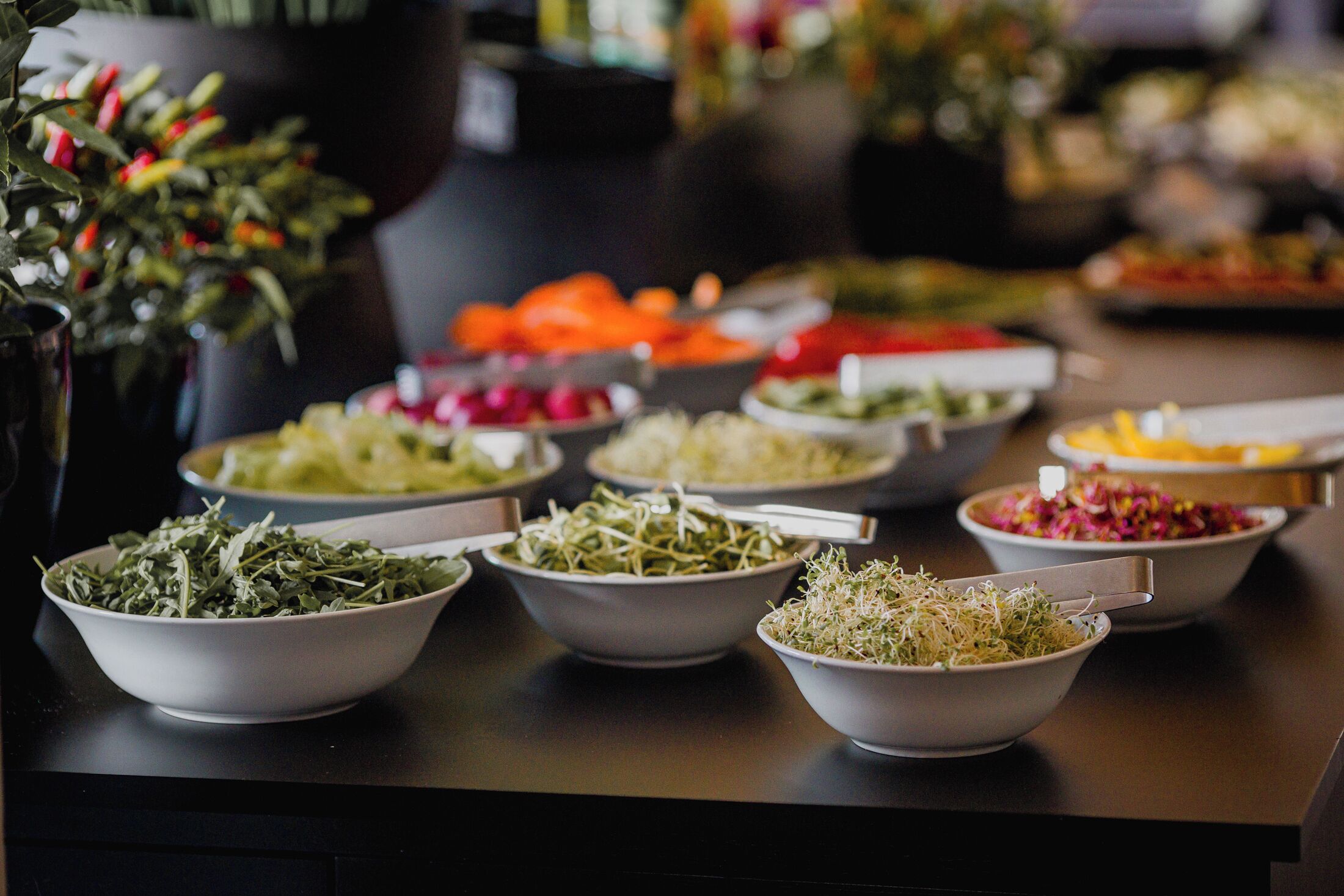 Una mesa de buffet con diversos platos, incluyendo ensaladas, verduras y otros alimentos.