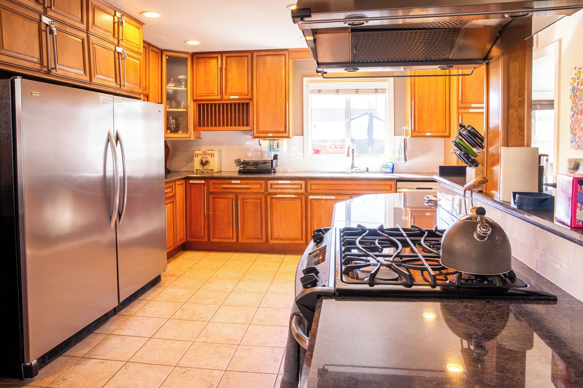 A kitchen with wooden cabinets, stainless steel appliances, and a gas stove.