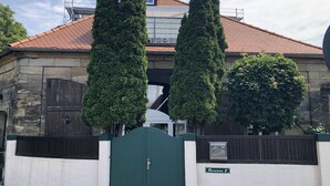 A building with a stone facade, a green gate, and a sign reading "Rosenau 2". - Penthouse 1872 (Bayreuth)