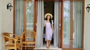 A room with a sliding glass door, a wooden chair, and a number '3' on the wall. - Sedana Cottage (Pererenan)