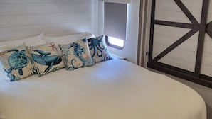 Una camera da letto con un letto grande, una finestra con tende e un pannello di legno al muro.