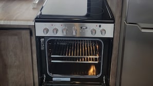 Una cucina dotata di forno a microonde, forno e frigorifero.
