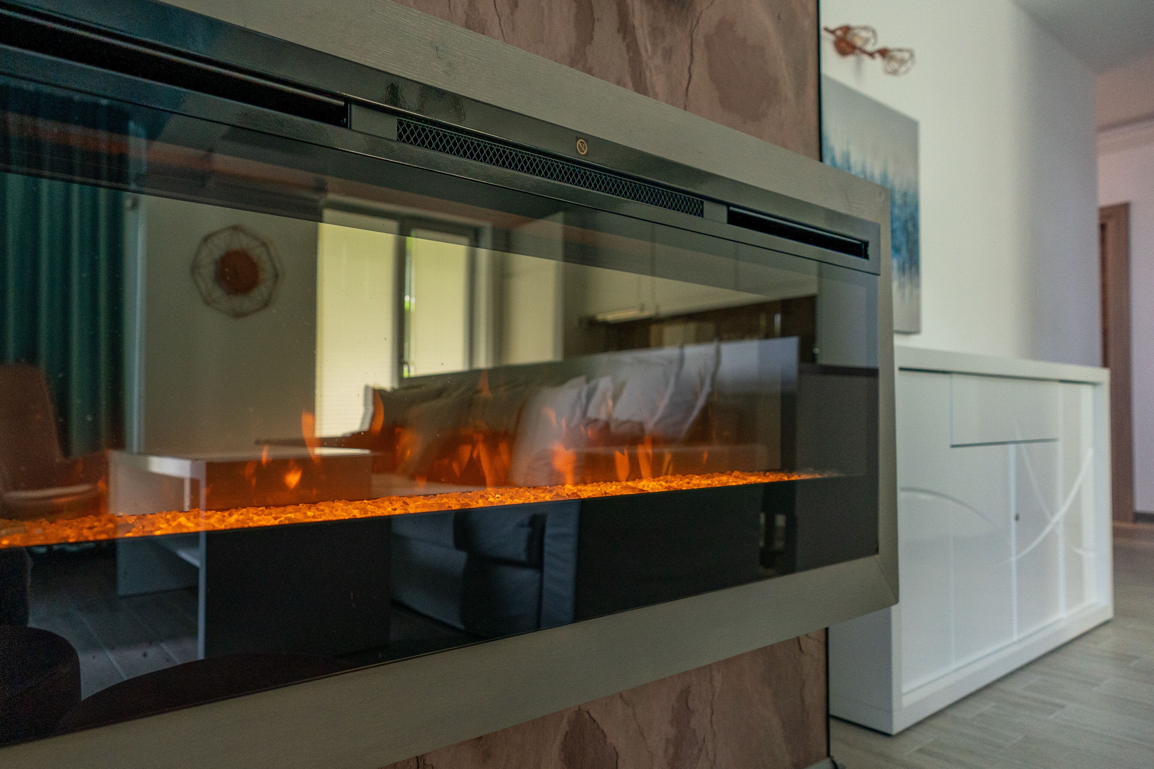A modern kitchen with a built-in stove and a glass backsplash.