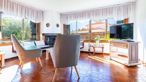 A modern living room with a sofa, armchairs, a TV, and a fireplace. - Villa Monbijou with Private Pool & Wi-Fi close to the Beach (Vinarós)