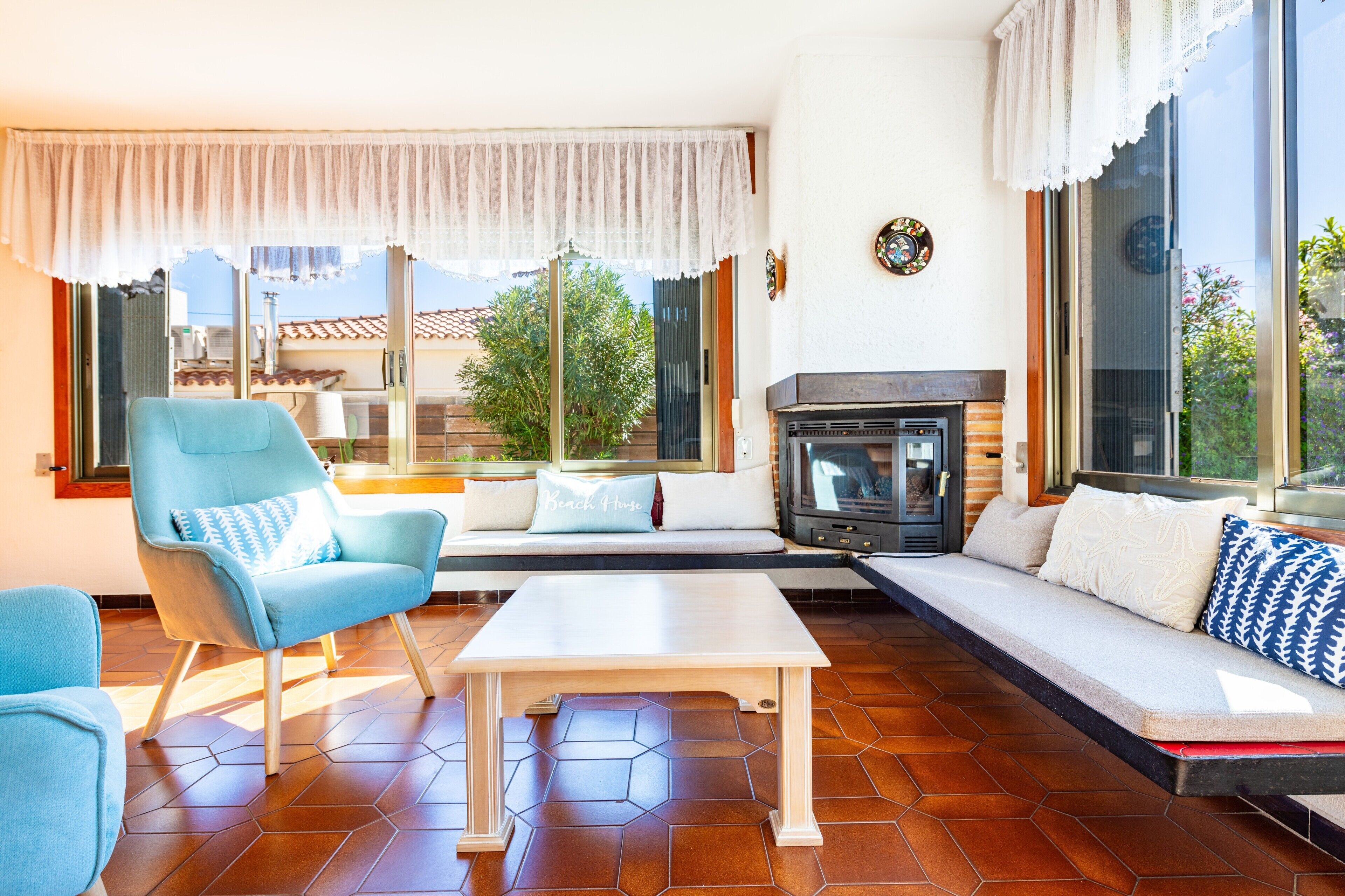 Una sala de estar con un sofá, una silla, una mesa y una chimenea.