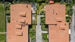 An aerial view of a residential area with two buildings featuring red-tiled roofs, surrounded by green spaces and pathways. - Studio Residence Valle Fiorita with Shared Pool & Wi-Fi in Riotorto (Piombino)
