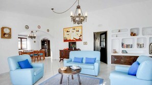 A spacious living room with two light blue sofas, a coffee table, and a chandelier. - Villa Brigida with Sea View, Heated Pool & Wi-Fi (São Rafael)