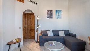 A living room with a sofa, a small table, a lamp, and two wall art pieces. - "Elegante appartamento centro" with 2 Terraces & Wi-Fi (san teodoro)