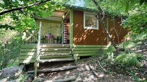 Eine Holzhütte mit Veranda, Treppe und Fenster.