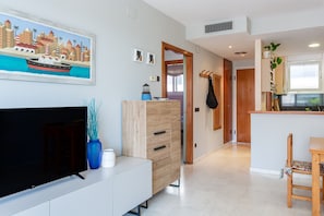 Una sala de estar moderna con televisión de pantalla plana, mueble de madera y obra de arte en la pared.