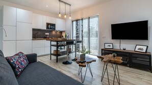 Un espacio habitable moderno con cocina, comedor y televisor de pantalla plana.