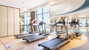 A fitness center with treadmills, a stationary bike, and a large exercise ball. - Staycae Celestia (Dubai)