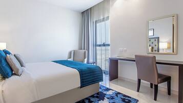 Quarto de hotel moderno com uma cama grande, uma escrivaninha e uma cadeira.