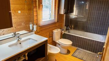 A bathroom with a wooden vanity, a sink, a toilet, and a shower.