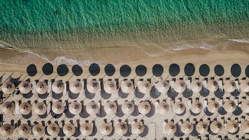 Di pantai, kursi berjemur, payung pantai, dan pijat di pantai