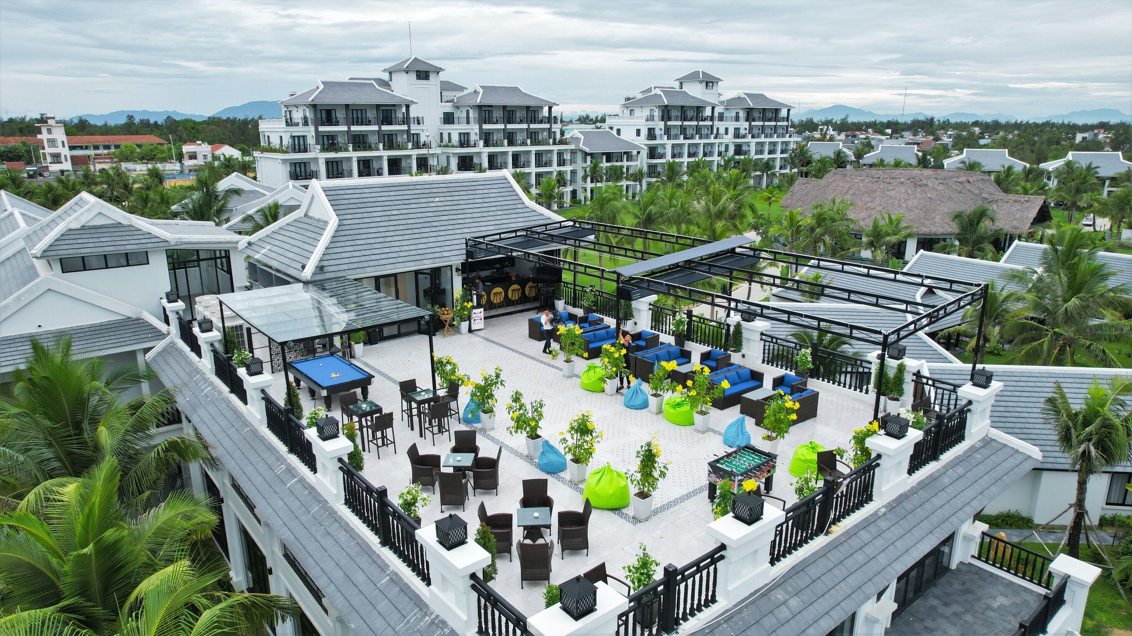 A rooftop bar with outdoor seating, a pool table, and a bar area.