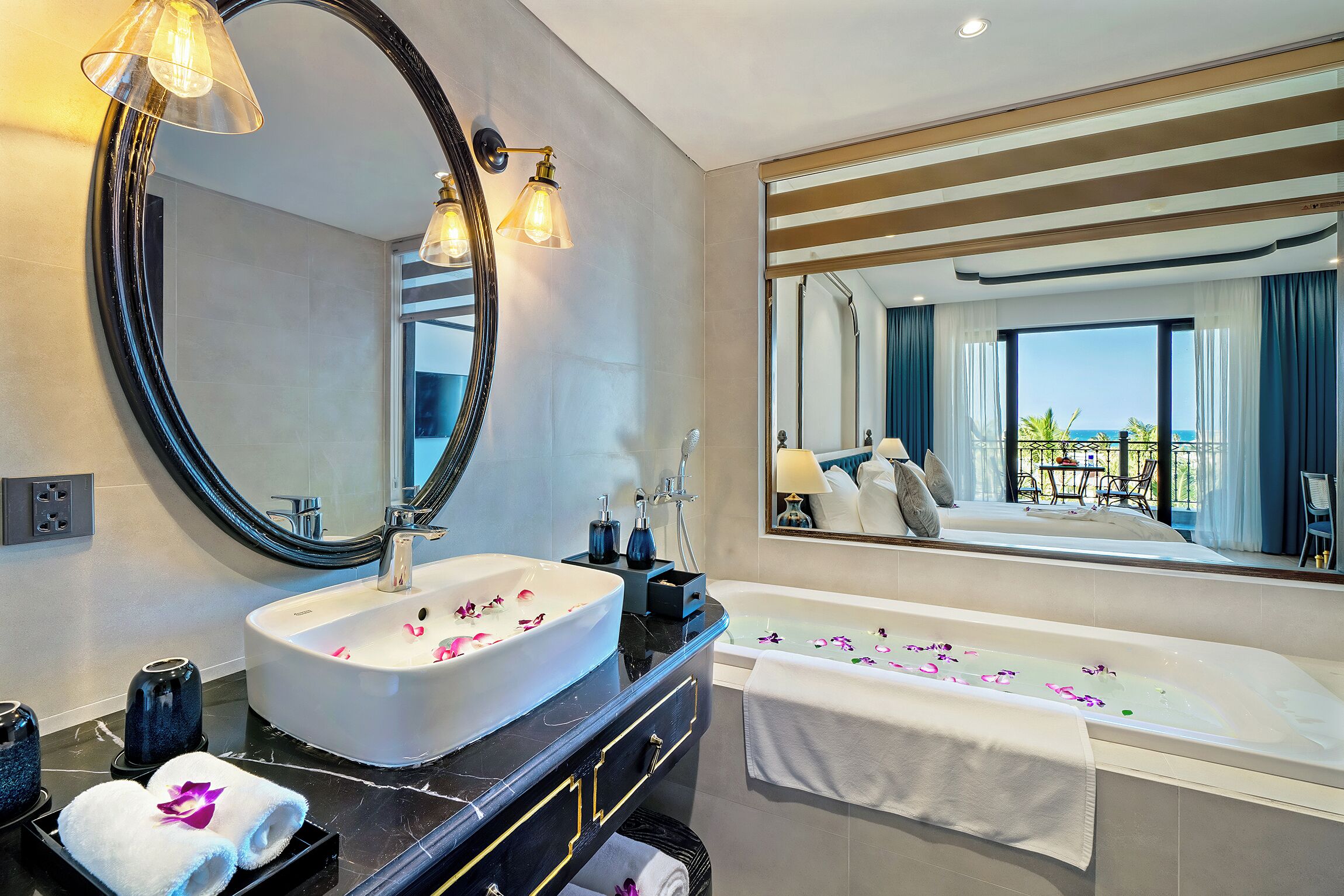 A modern bathroom with a large oval sink, a freestanding bathtub, and a large mirror.