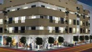 Ett hotell med flera våningar, ett platt tak, många fönster och en entré i markplan med en röd matta.
