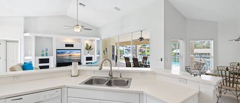 A modern kitchen with a large island, built-in appliances, and a view of the outdoors.