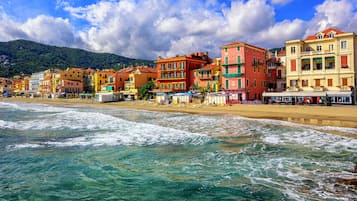 Un paese costiero con edifici colorati, una spiaggia e onde.