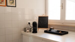 A kitchen counter with a coffee maker, a toaster, and a blackboard with writing. - Tre Balconi Sul Mare - Beachfront Sea-view Apartment (Borghetto Santo Spirito)