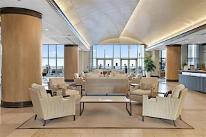 A spacious lobby with a central seating area, large windows, and a reception desk.