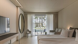 Une chambre d’hôtel moderne dotée d’un grand lit, d’un bureau, d’une chaise et offrant une vue sur l’espace extérieur abritant une piscine.