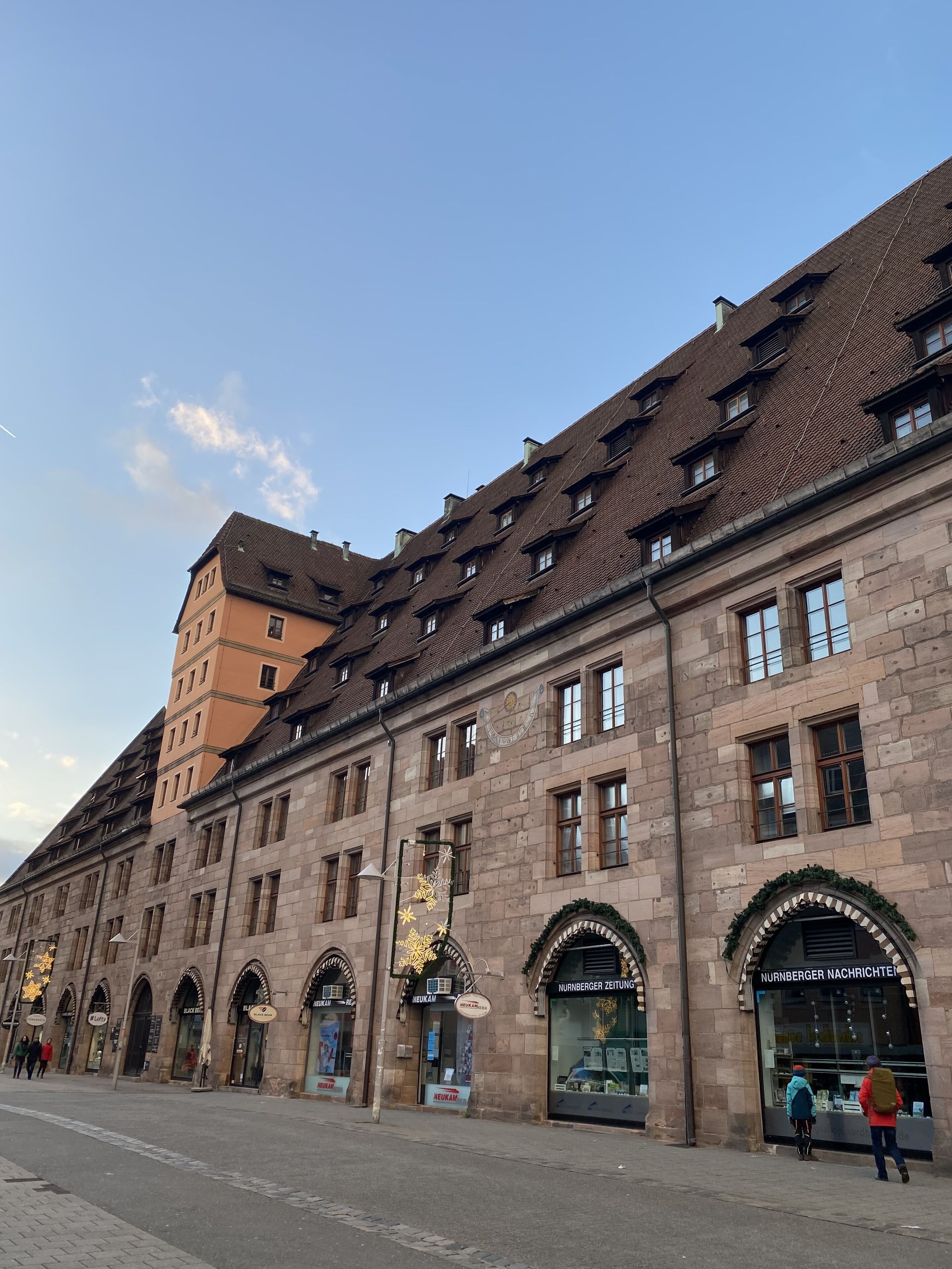 A historic building with multiple windows and arched doorways, likely a hotel or public building.
