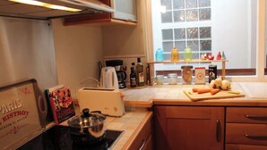 Una cucina con un fornello, un tostapane e diversi oggetti da cucina sul bancone.
