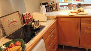 Una cucina con un fornello, un tostapane e diversi oggetti da cucina sul bancone.