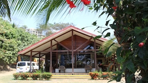 A building with a sloped roof and a covered porch area.