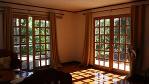 A room with large windows, a tiled floor, and a fan. - Farmstead vacation house in the middle of Sabang and Dinadiawan beach (Dipaculao)