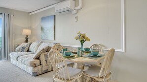 A dining area with a round table, chairs, and a vase of flowers. - Beachcrest 17-Oceanfront 76th St, Free WiFi, AC (Ocean City)
