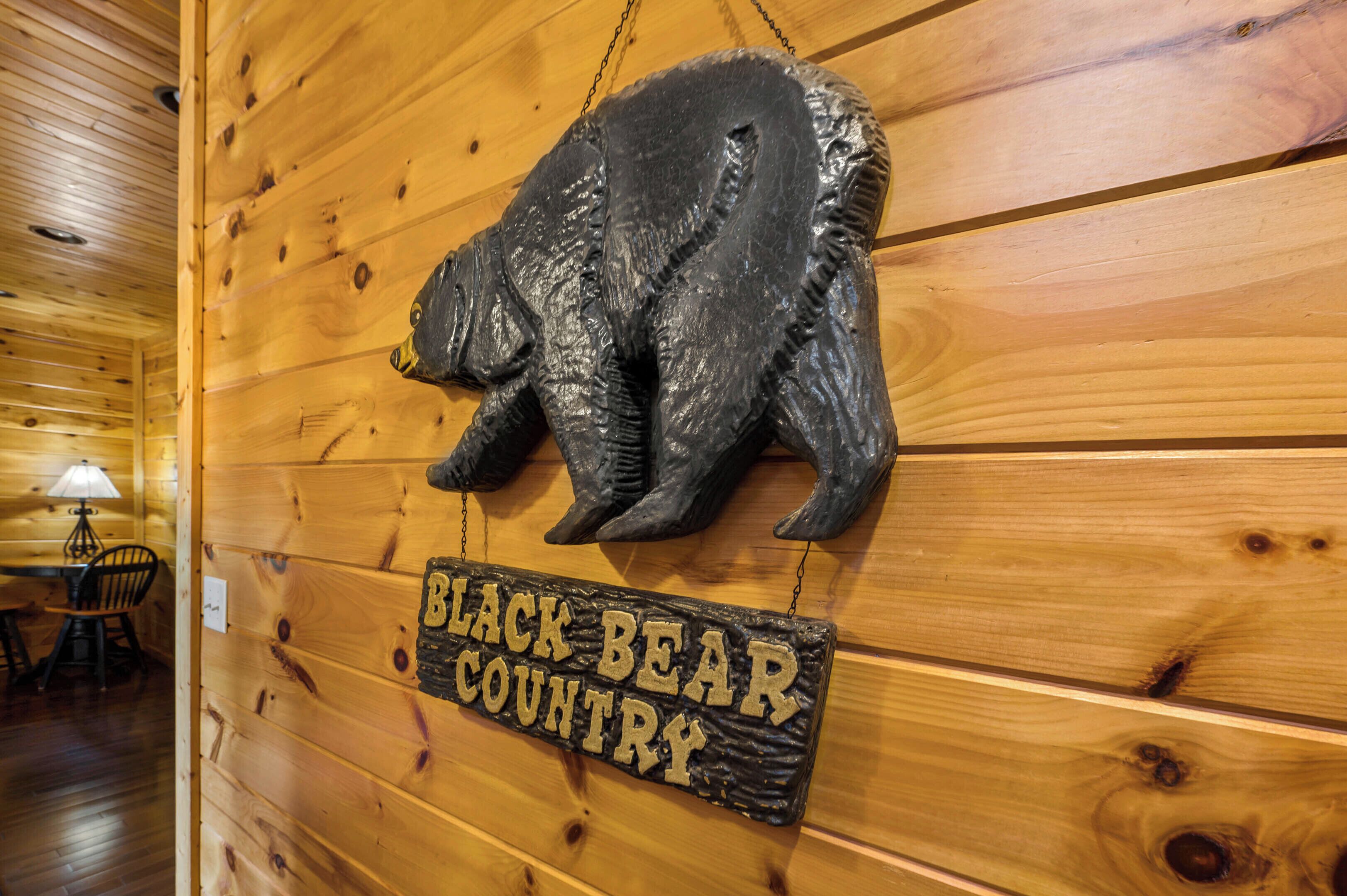 A wooden wall with a bear sculpture and a sign that reads "BLACK BEAR COUNTRY."