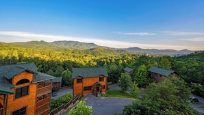 A lodge with a central building surrounded by lush greenery and mountains in the background. - Gorgeous Views, Hot Tub, Game Room, and Free Attraction Passes, Resort Pool (Gatlinburg,)