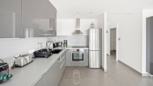 Een moderne keuken met roestvrijstalen apparatuur, een inbouwoven en een grote koelkast.