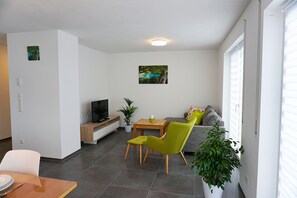 Un salon moderne avec un canapé, une table à manger et un téléviseur.