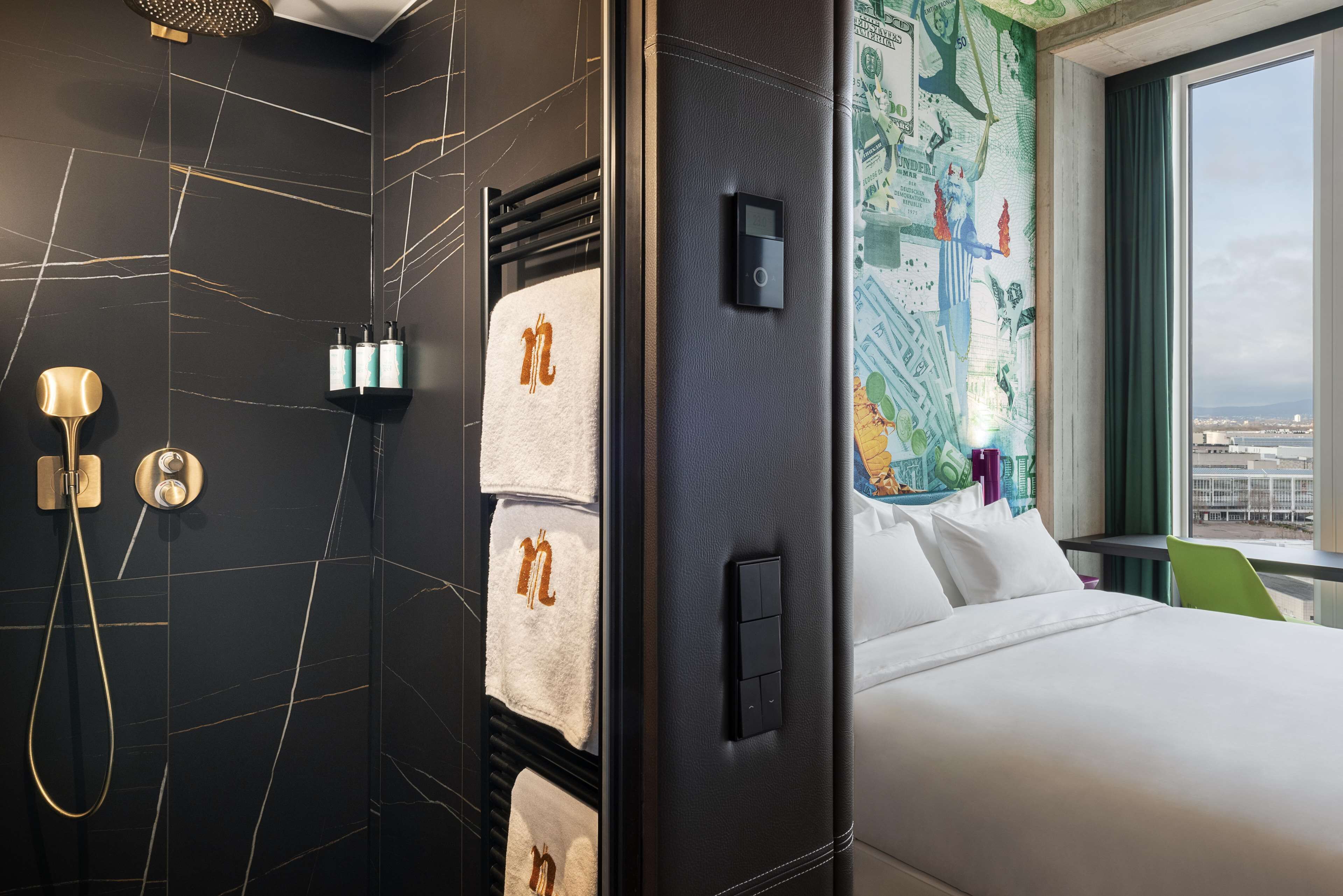 A hotel room with a bed, a shower area, and a wall with a map.