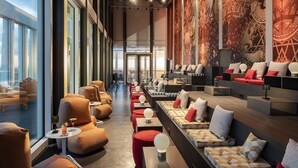 A modern hotel lobby with seating areas, large windows, and a decorative wall mural. - nhow Frankfurt (Frankfurt)