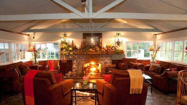 Una sala de estar acogedora con chimenea, asientos cómodos y ventanas amplias.