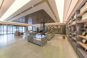 A spacious lobby with a reception desk, seating area, and a large bookshelf. - Ji Hotel (Wuhan)