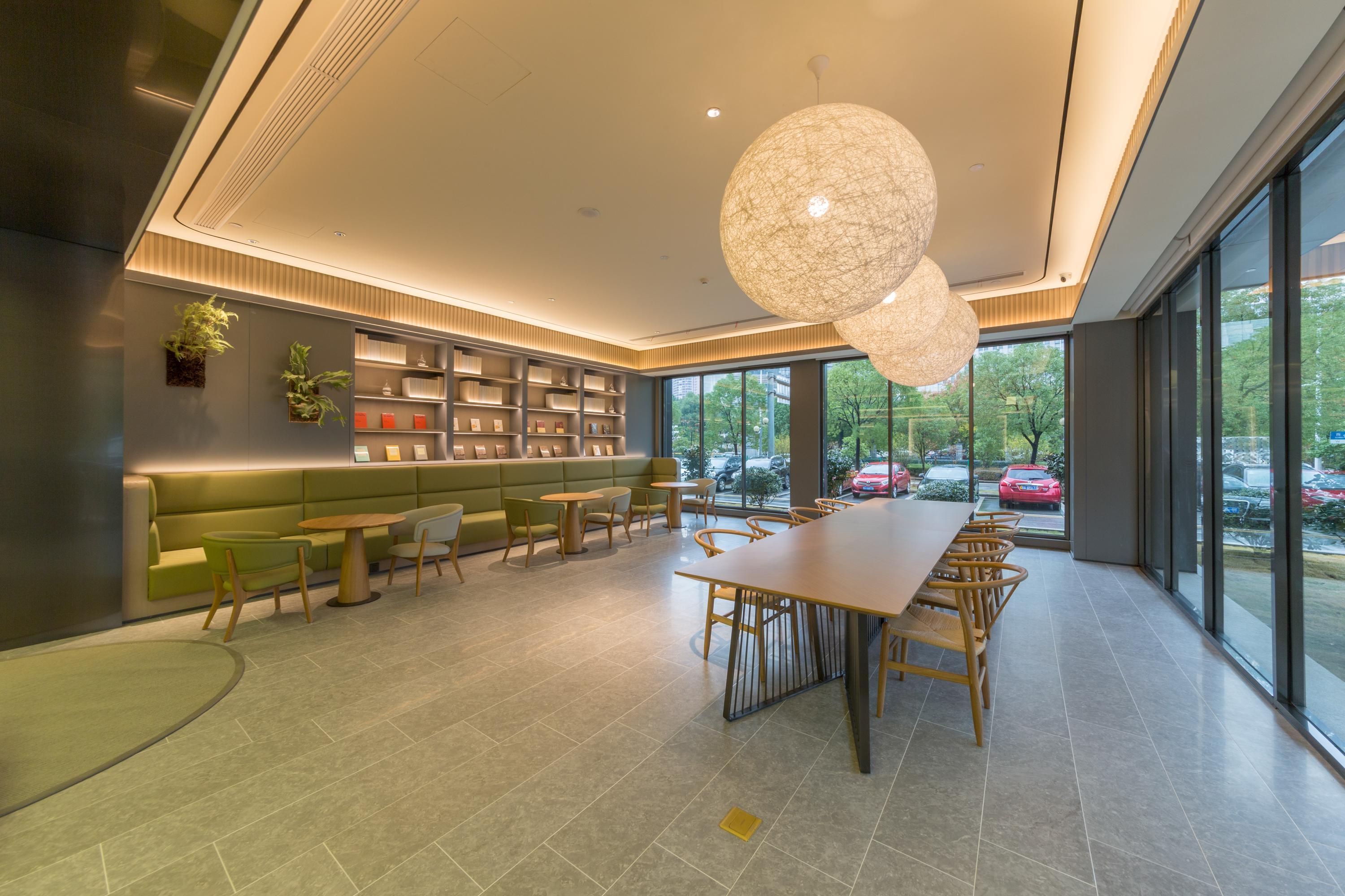 Un interior modern amb una taula de dinar llarga, seients i una biblioteca.