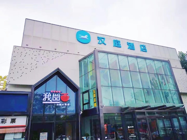 A hotel with a modern glass facade and a prominent sign indicating it is a Han Dynasty Hotel. - Hanting Hotel (Beijing)