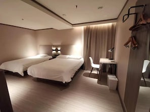A hotel room with two beds, a desk, a chair, and a wardrobe. - Hanting Hotel (Beijing)